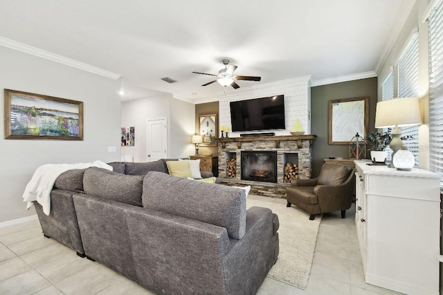 tiled living room with ceiling fan, a stone fireplace, and ornamental molding