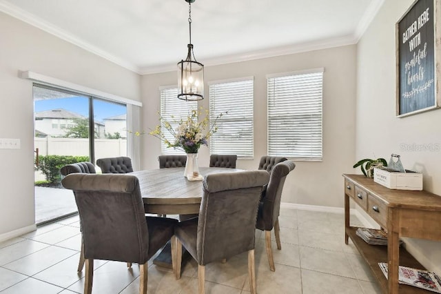 dining area with a notable chandelier, light tile patterned floors, and ornamental molding