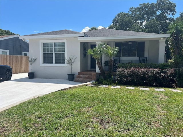 ranch-style home with ceiling fan and a front lawn