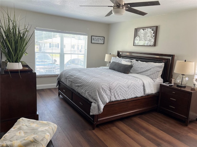 bedroom with multiple windows, a textured ceiling, dark hardwood / wood-style flooring, and ceiling fan