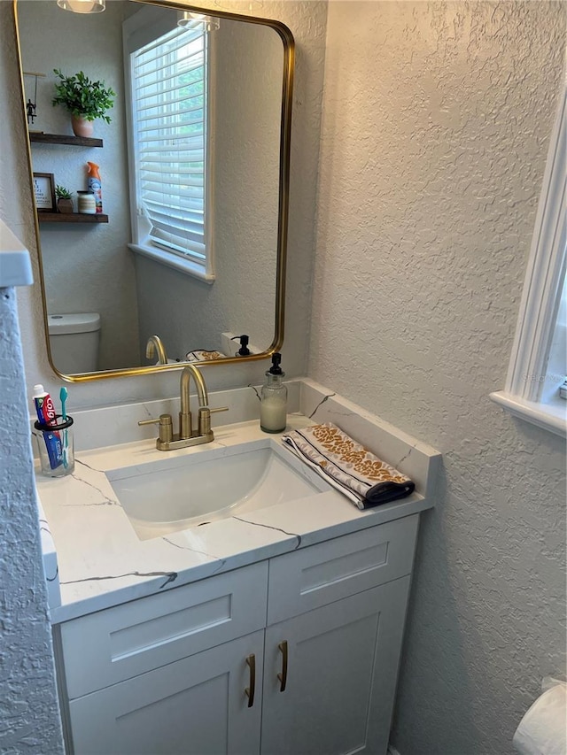 bathroom featuring vanity and toilet