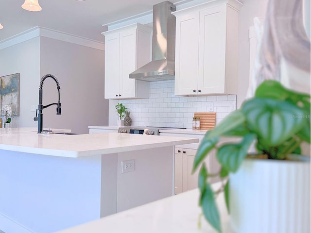 kitchen with white cabinets, backsplash, wall chimney exhaust hood, and sink