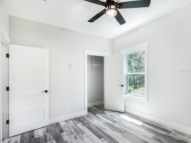 unfurnished bedroom featuring light wood-type flooring, ceiling fan, and a closet