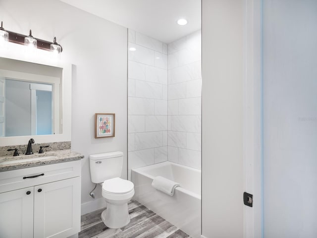 full bathroom with wood-type flooring, toilet, vanity, and tiled shower / bath combo