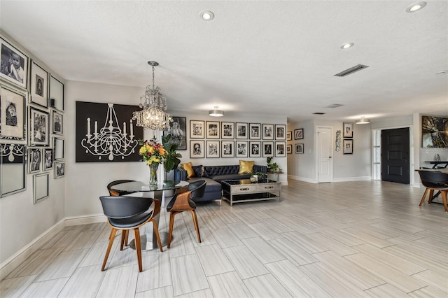 dining area featuring an inviting chandelier and a textured ceiling