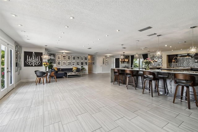 interior space with decorative light fixtures, a chandelier, and a breakfast bar area