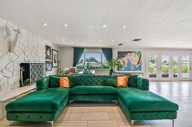 living room with french doors, a fireplace, and a textured ceiling