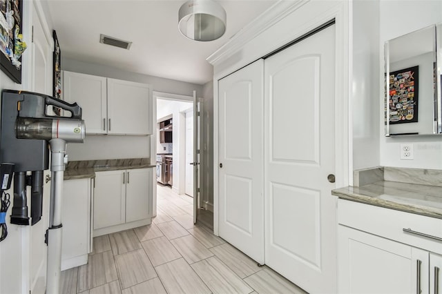 kitchen featuring stone counters and white cabinets