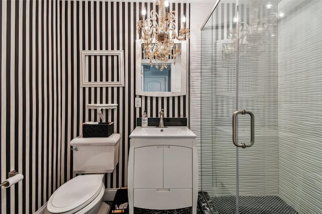 bathroom with vanity, a notable chandelier, toilet, and walk in shower