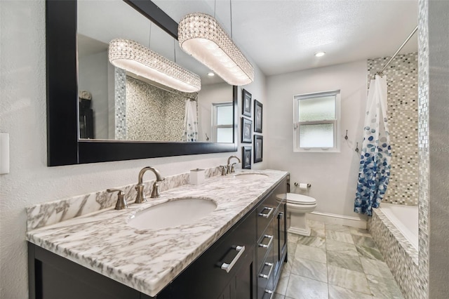 full bathroom with shower / tub combo with curtain, vanity, a textured ceiling, and toilet