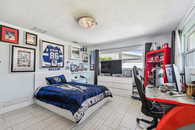 bedroom with multiple windows and a textured ceiling