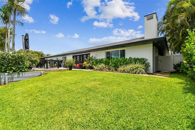 rear view of property featuring a yard