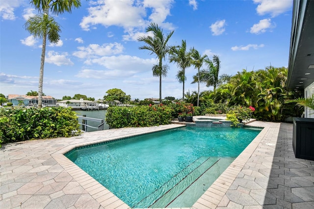 view of pool with an in ground hot tub and a water view