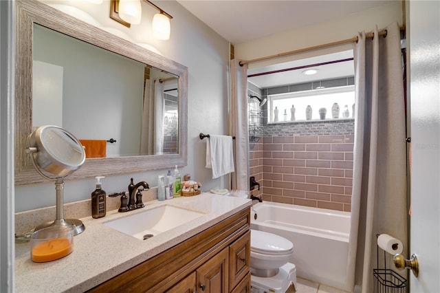 full bathroom featuring vanity, tiled shower / bath, and toilet