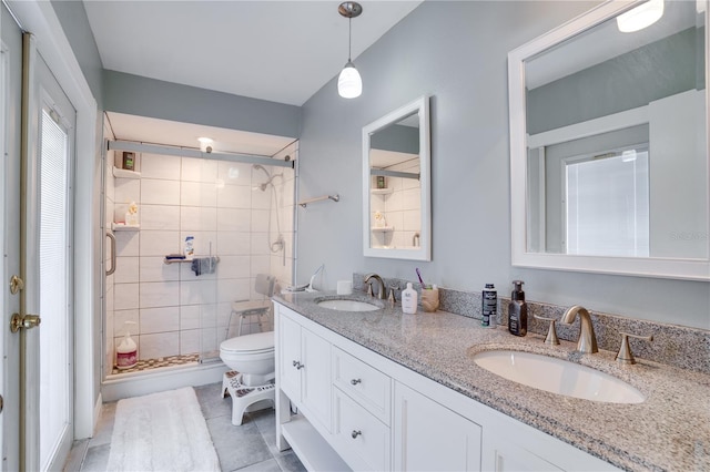 bathroom featuring tile patterned flooring, vanity, toilet, and an enclosed shower