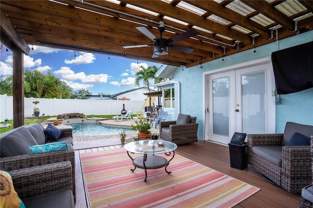 wooden deck with a fenced in pool, ceiling fan, french doors, and an outdoor hangout area