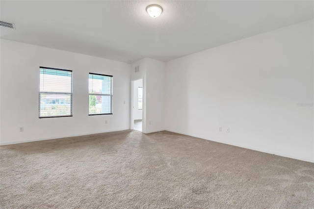 carpeted spare room with a textured ceiling