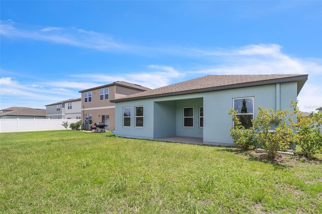 rear view of property with a lawn and a patio area