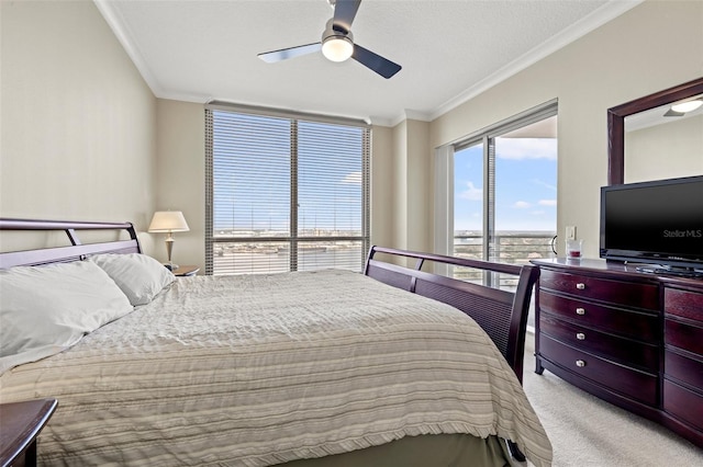 carpeted bedroom with ceiling fan and crown molding