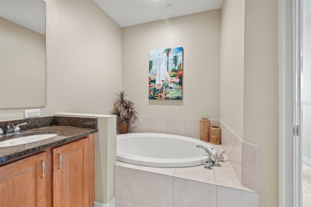 bathroom featuring vanity and a relaxing tiled tub