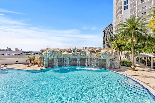 view of pool featuring pool water feature and a patio