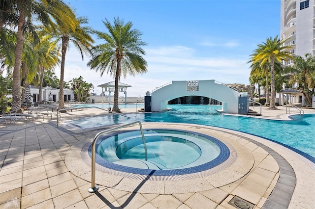 view of swimming pool with a hot tub and a patio area