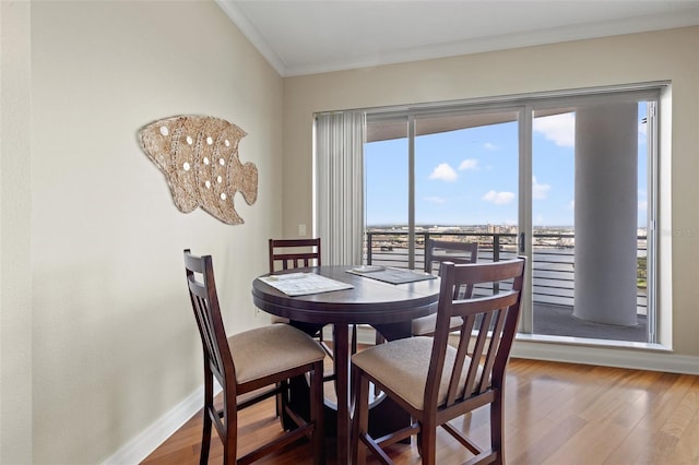 dining area with crown molding, plenty of natural light, hardwood / wood-style floors, and an inviting chandelier