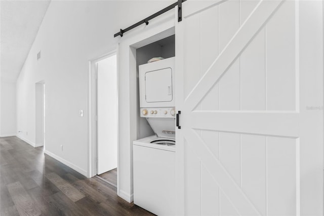 laundry room with dark hardwood / wood-style flooring and stacked washer / dryer