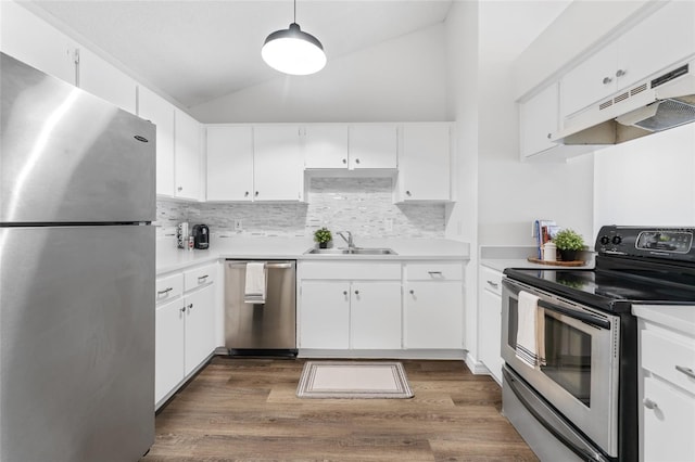 kitchen with vaulted ceiling, stainless steel appliances, white cabinetry, and sink