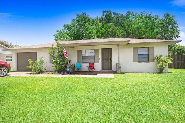 ranch-style house featuring stucco siding, a front yard, fence, a garage, and driveway