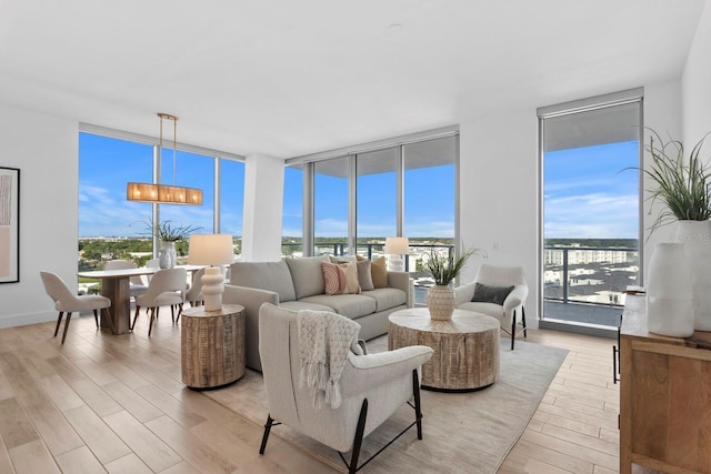 living room with plenty of natural light, light hardwood / wood-style flooring, and floor to ceiling windows