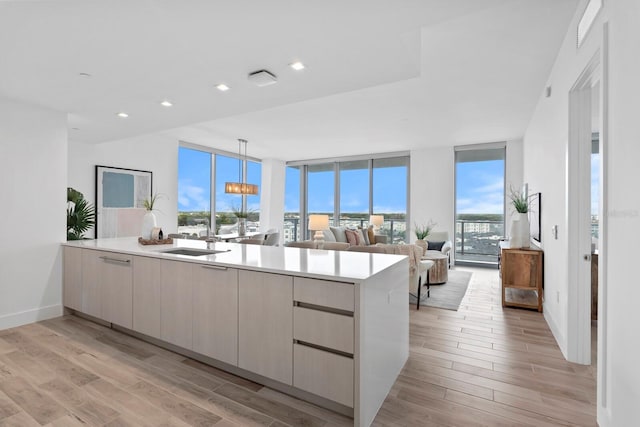 kitchen with sink, plenty of natural light, a wall of windows, and hanging light fixtures