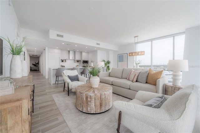 living room featuring light hardwood / wood-style flooring and floor to ceiling windows