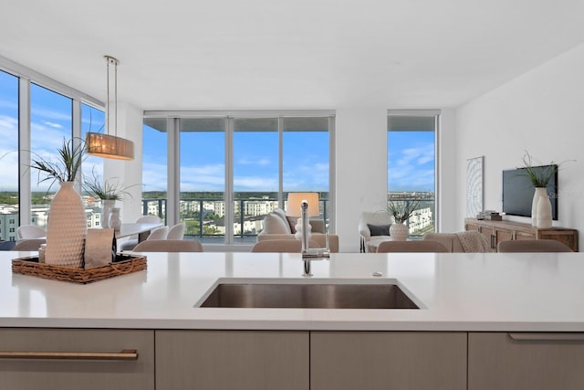 kitchen with decorative light fixtures, sink, and expansive windows