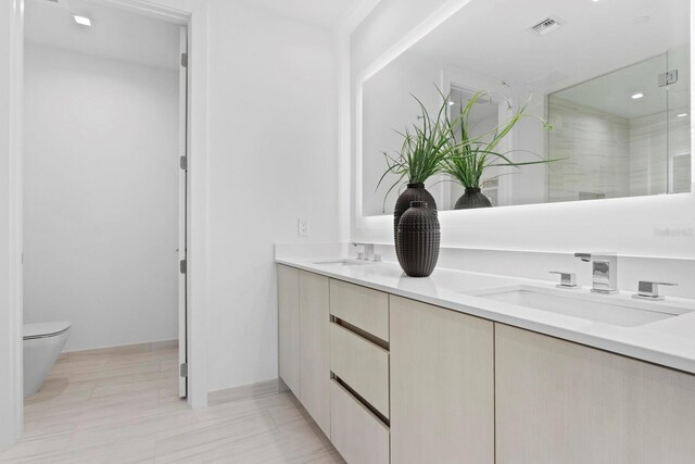 bathroom featuring vanity, toilet, and an enclosed shower