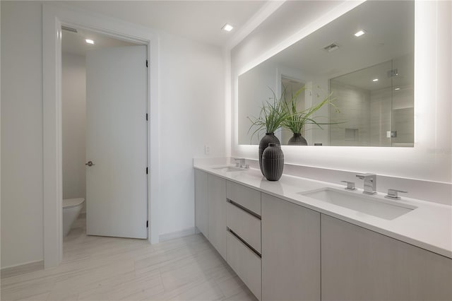 bathroom with toilet, walk in shower, and vanity