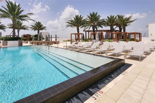 view of swimming pool with a water view, a pergola, and a patio area