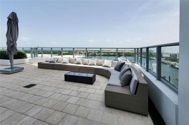 view of patio featuring a balcony, a water view, and outdoor lounge area