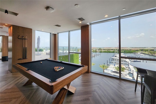 recreation room featuring dark parquet floors, a water view, a wall of windows, and billiards