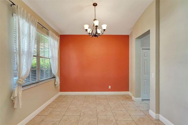 unfurnished room with a notable chandelier and light tile patterned floors