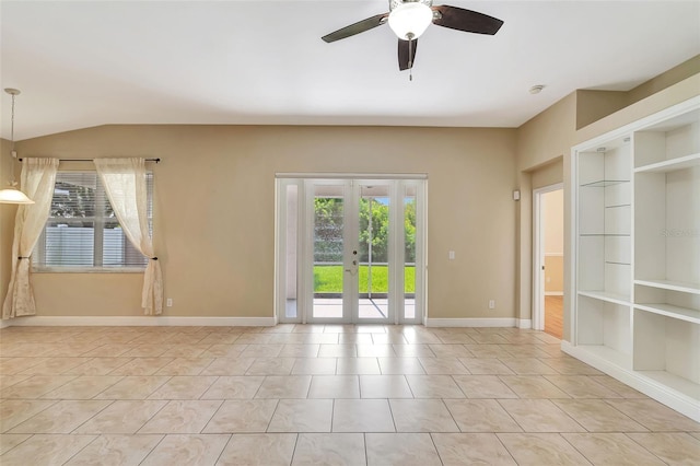 empty room with plenty of natural light, built in shelves, and french doors