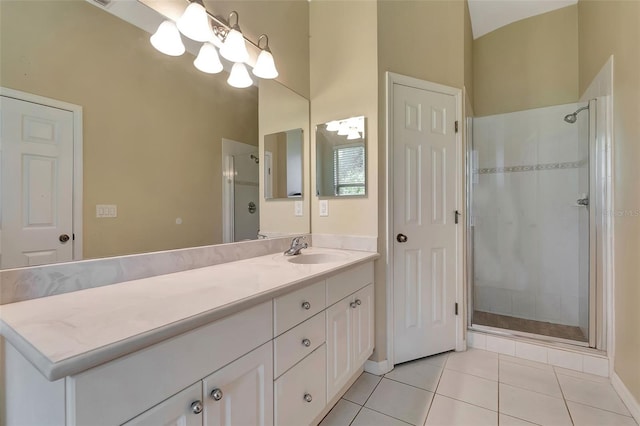 bathroom featuring tile patterned floors, a shower with door, and vanity