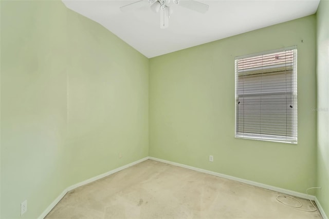 spare room featuring light colored carpet, vaulted ceiling, and ceiling fan