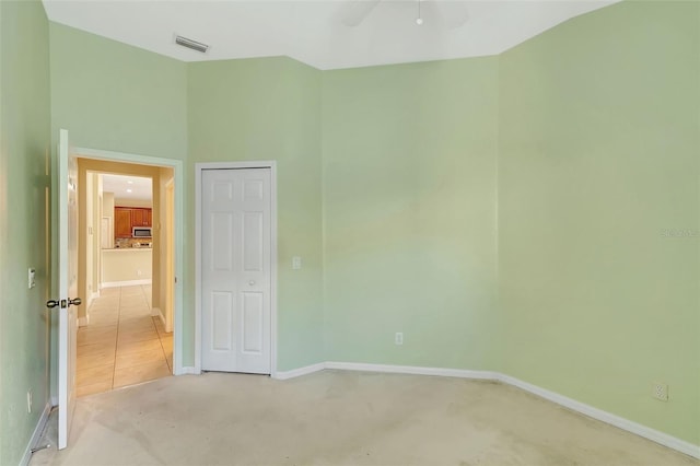 empty room with light colored carpet and ceiling fan