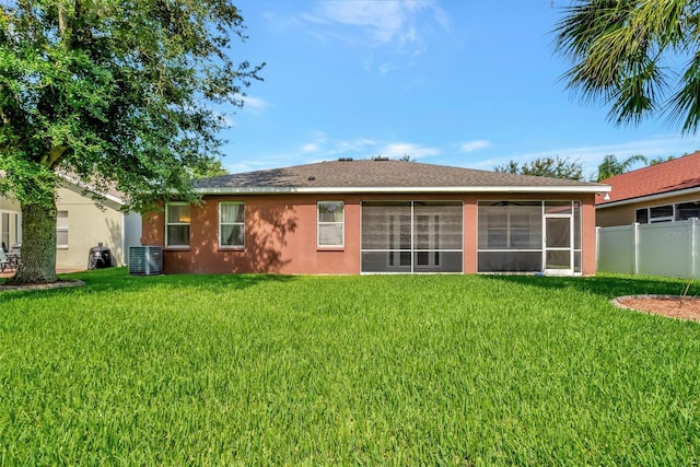 back of property with central air condition unit and a lawn