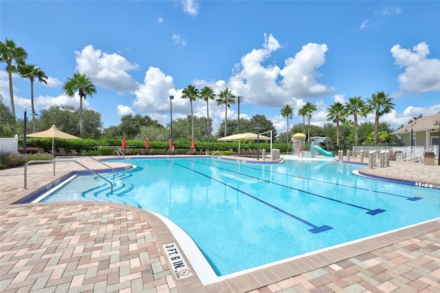 view of pool with a patio area and a water slide