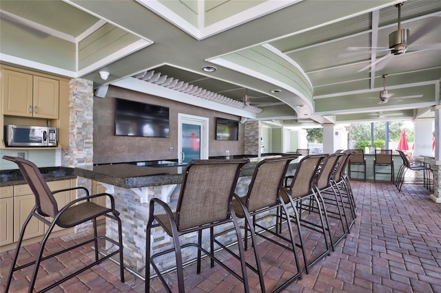 exterior space with ceiling fan and an outdoor bar