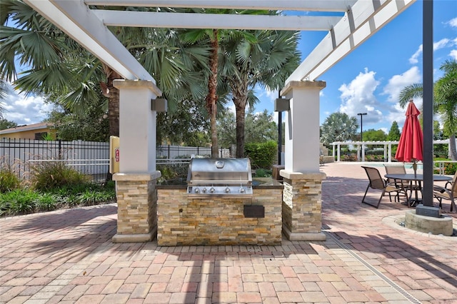 view of patio / terrace featuring a pergola, area for grilling, and an outdoor kitchen