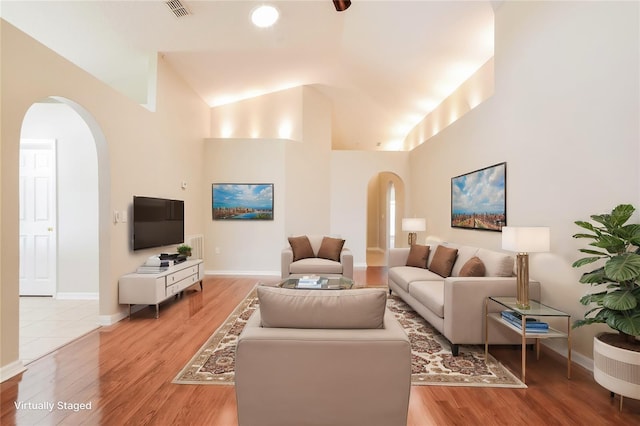 living room with high vaulted ceiling and light hardwood / wood-style floors