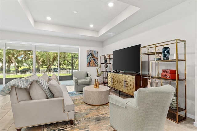 living room featuring a raised ceiling and light tile patterned floors